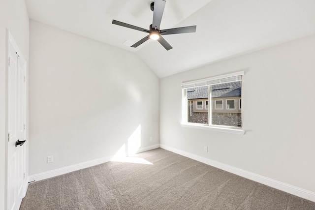 empty room with ceiling fan, lofted ceiling, and carpet flooring