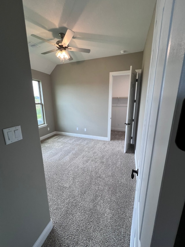 unfurnished room with carpet floors, ceiling fan, and vaulted ceiling