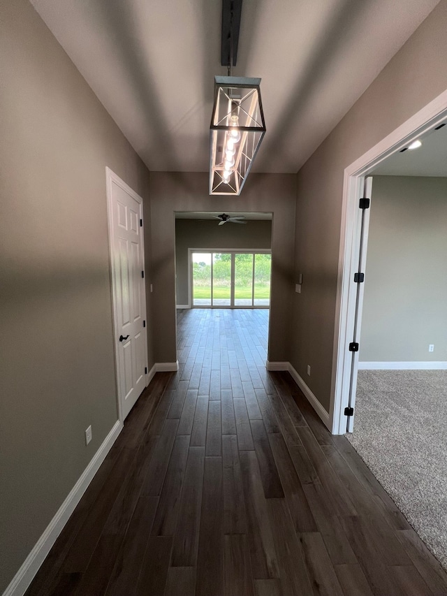 hallway featuring dark carpet