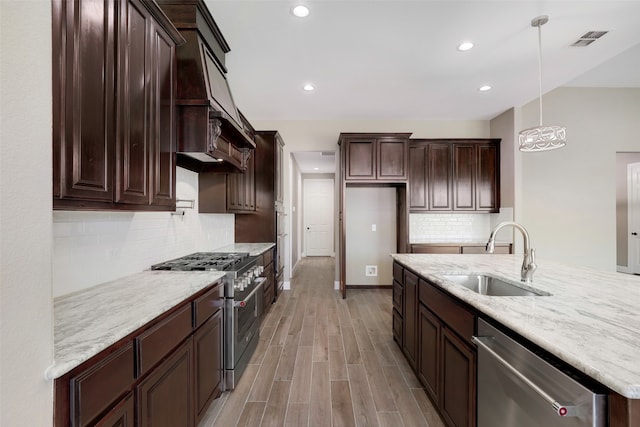 kitchen featuring hanging light fixtures, sink, decorative backsplash, and stainless steel appliances