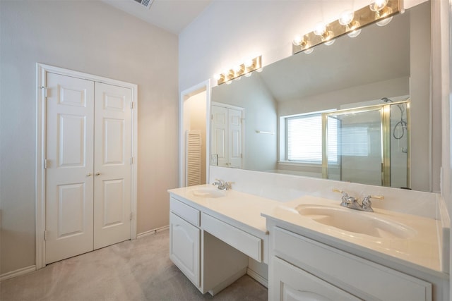 bathroom featuring a shower with door and vanity