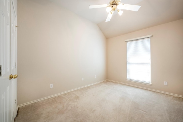 empty room featuring ceiling fan, light carpet, and vaulted ceiling