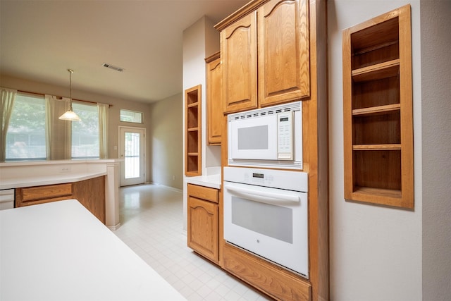 kitchen featuring decorative light fixtures and white appliances