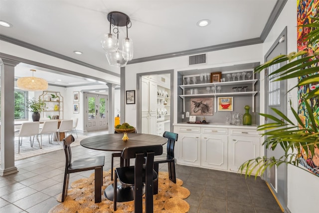 dining room with crown molding, dark tile patterned floors, ornate columns, and french doors