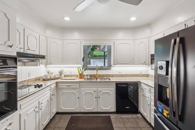 kitchen featuring dark tile patterned flooring, sink, white cabinetry, and black appliances