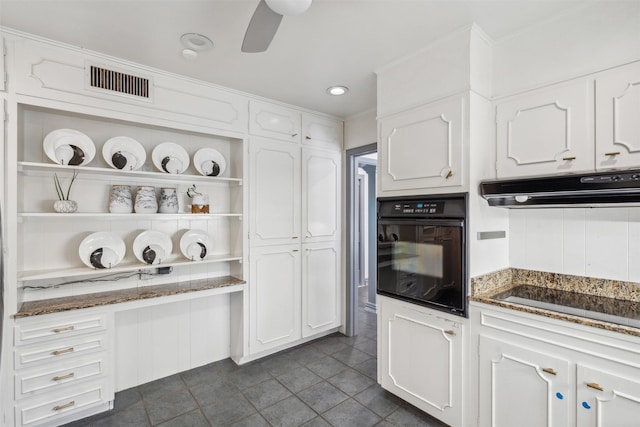 kitchen with cooktop, white cabinetry, and oven