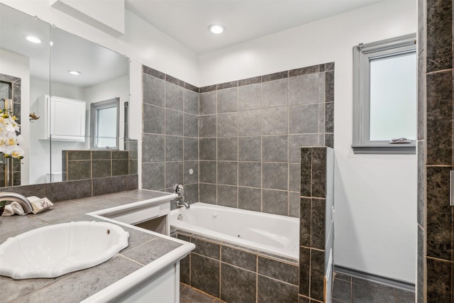 bathroom featuring vanity and tiled tub