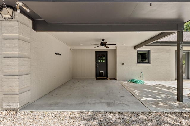 view of exterior entry with ceiling fan and a patio area