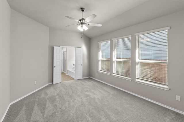 unfurnished bedroom featuring ceiling fan, light colored carpet, and vaulted ceiling