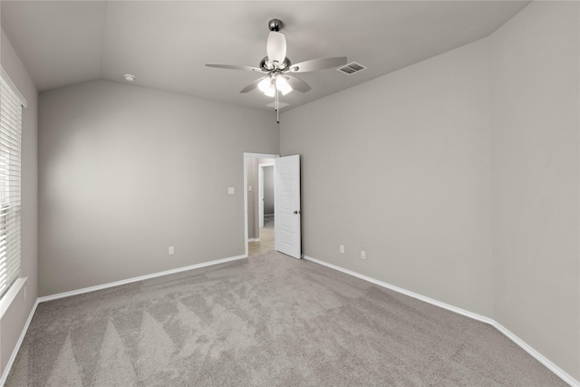 carpeted empty room with ceiling fan, a healthy amount of sunlight, and vaulted ceiling