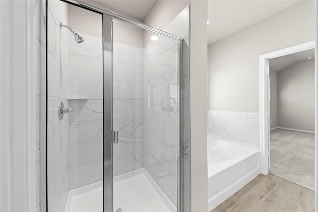 bathroom with wood-type flooring and independent shower and bath