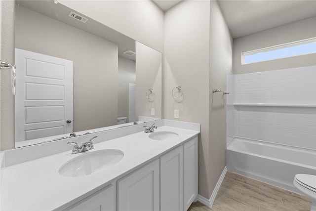 full bathroom featuring toilet, vanity, washtub / shower combination, and hardwood / wood-style flooring