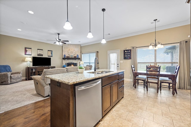 kitchen with pendant lighting, dishwasher, a center island with sink, ceiling fan with notable chandelier, and sink