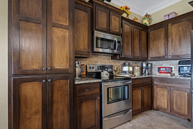 kitchen with light stone countertops, stainless steel appliances, tasteful backsplash, crown molding, and dark brown cabinets