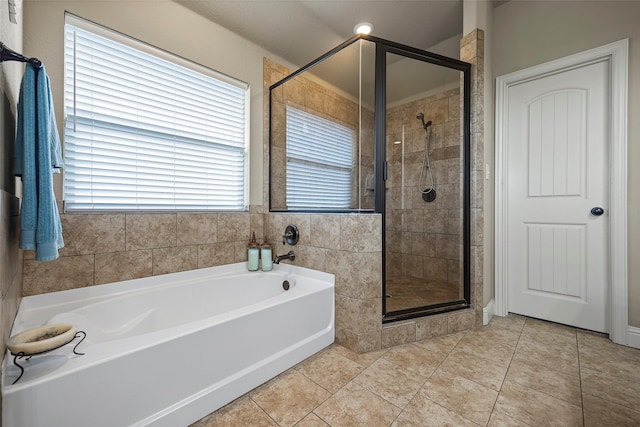 bathroom with separate shower and tub and tile patterned flooring