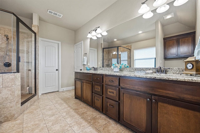 bathroom with vanity, tile patterned floors, and a shower with door