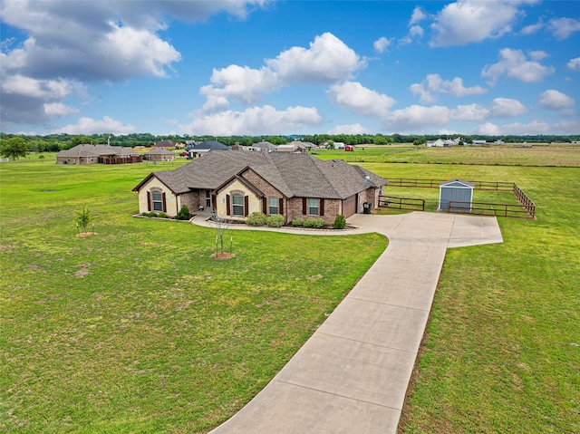 view of front of property featuring a garage, a rural view, and a front lawn