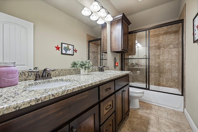 full bathroom featuring vanity, toilet, and bath / shower combo with glass door