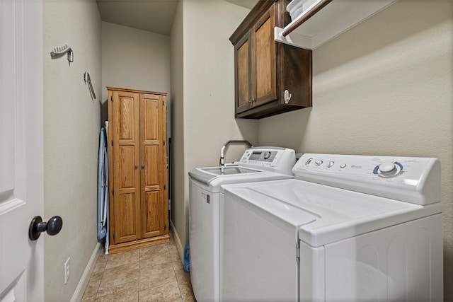 laundry room with cabinets, light tile patterned floors, and washer and clothes dryer