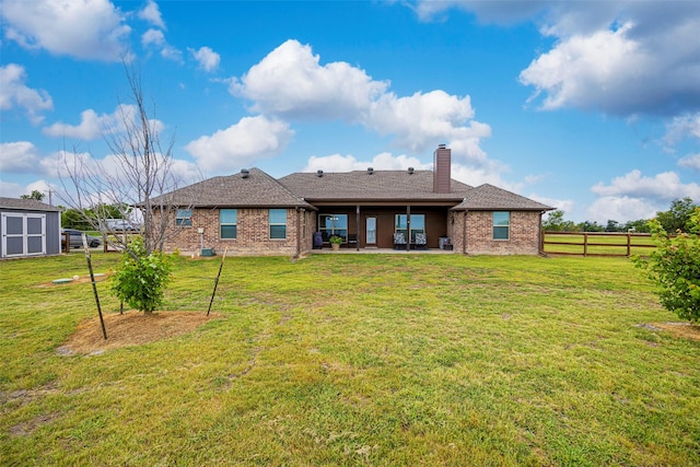 back of house featuring a yard and a patio area