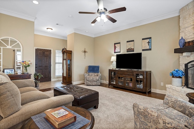 living room with a fireplace, wood-type flooring, ceiling fan, and crown molding