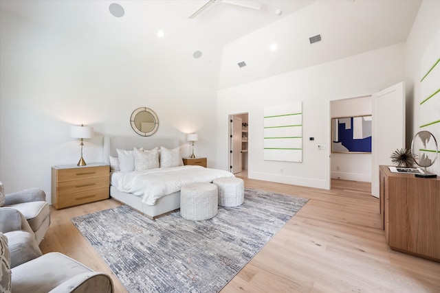 bedroom featuring ceiling fan, light wood-type flooring, and high vaulted ceiling