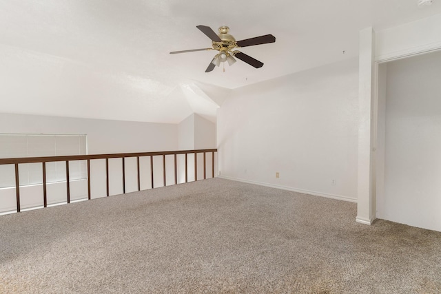 carpeted spare room with ceiling fan and lofted ceiling