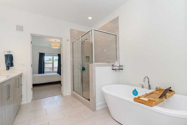 bathroom with tile patterned floors, separate shower and tub, and vanity