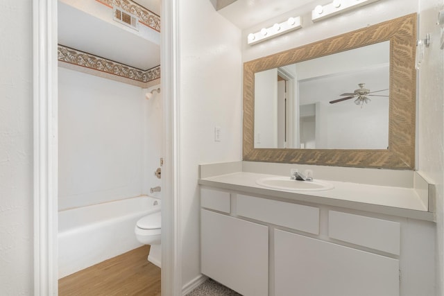 full bathroom with toilet, hardwood / wood-style flooring, ceiling fan, tub / shower combination, and vanity