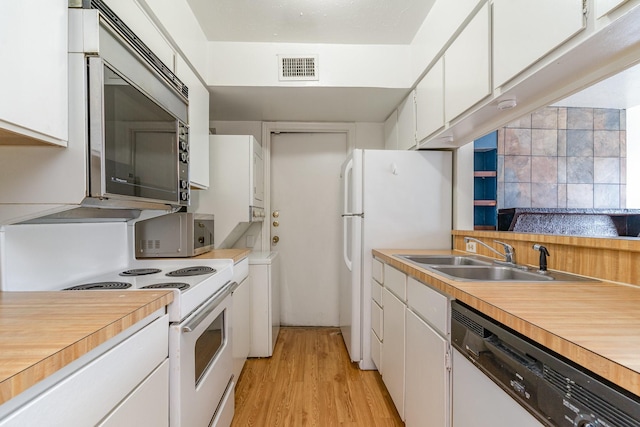 kitchen with light wood-type flooring, sink, white cabinets, and white appliances