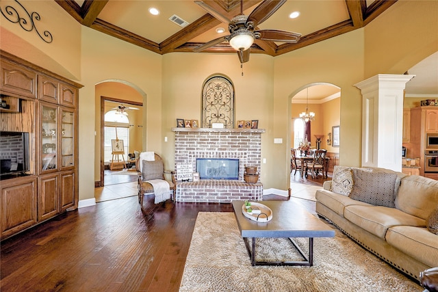 living room with ceiling fan with notable chandelier, beamed ceiling, coffered ceiling, and ornamental molding