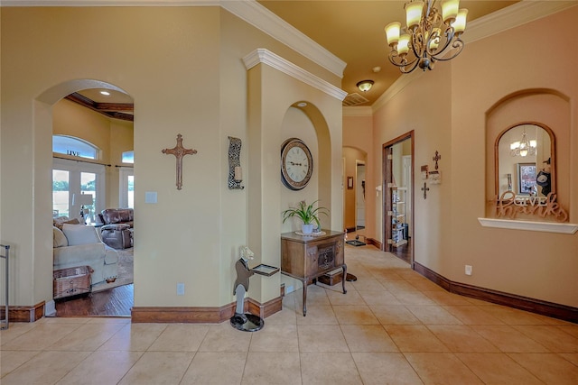 hall featuring french doors, crown molding, a chandelier, a high ceiling, and light tile patterned flooring