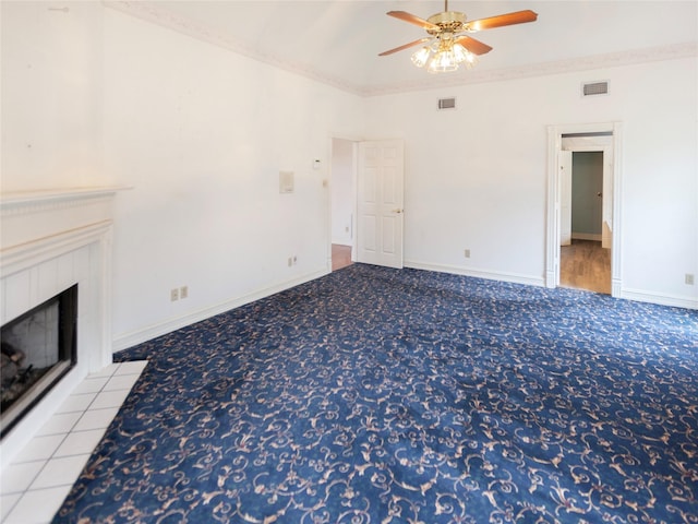 unfurnished living room featuring ceiling fan, carpet flooring, crown molding, and a fireplace