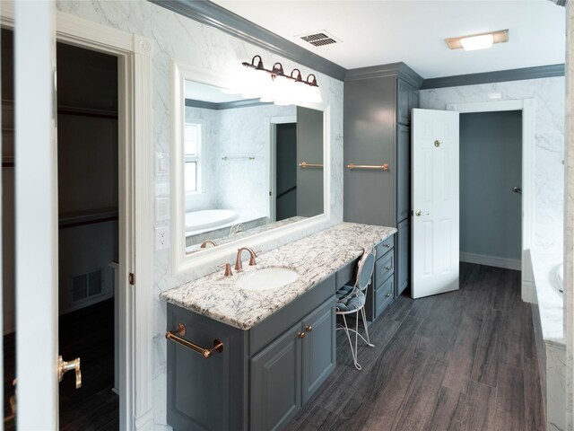 bathroom with hardwood / wood-style flooring, vanity, and ornamental molding