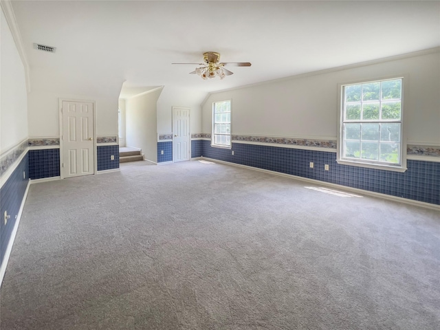 interior space with ceiling fan, vaulted ceiling, and carpet