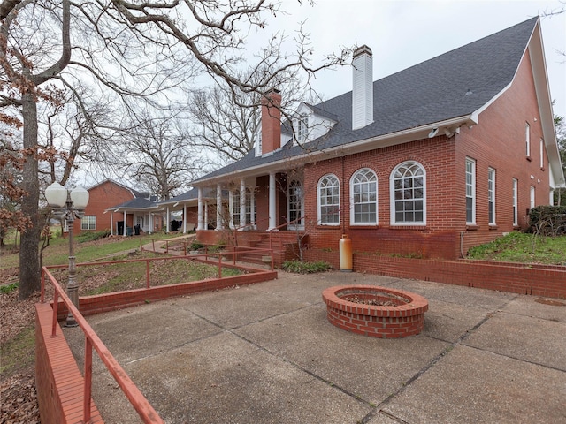 rear view of property featuring a fire pit