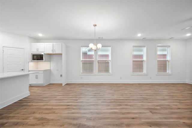 interior space featuring an inviting chandelier, a healthy amount of sunlight, and light hardwood / wood-style flooring