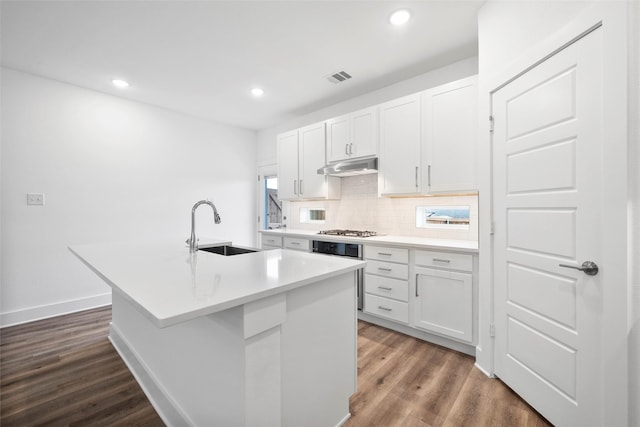 kitchen with sink, a center island with sink, dark hardwood / wood-style floors, white cabinetry, and stainless steel gas stovetop