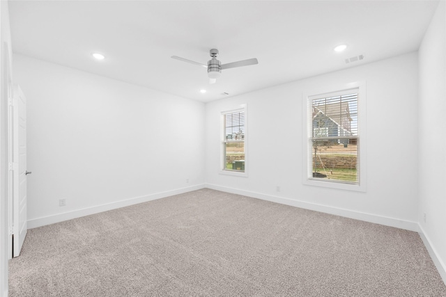 empty room featuring ceiling fan, plenty of natural light, and carpet floors