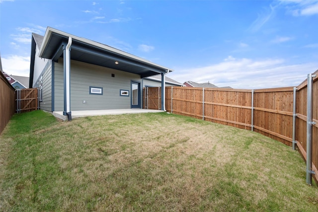 rear view of property featuring a yard and a patio area