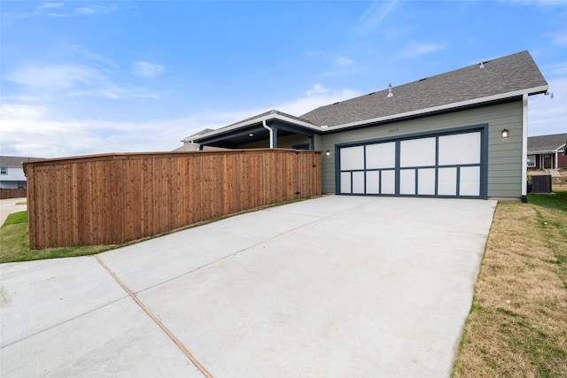 view of side of home featuring a garage and central AC