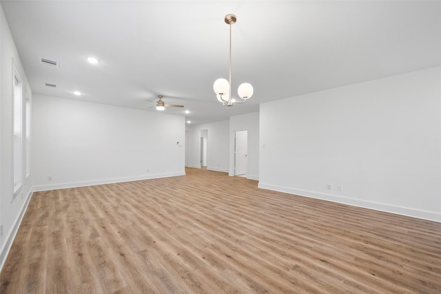 interior space featuring ceiling fan with notable chandelier and light wood-type flooring