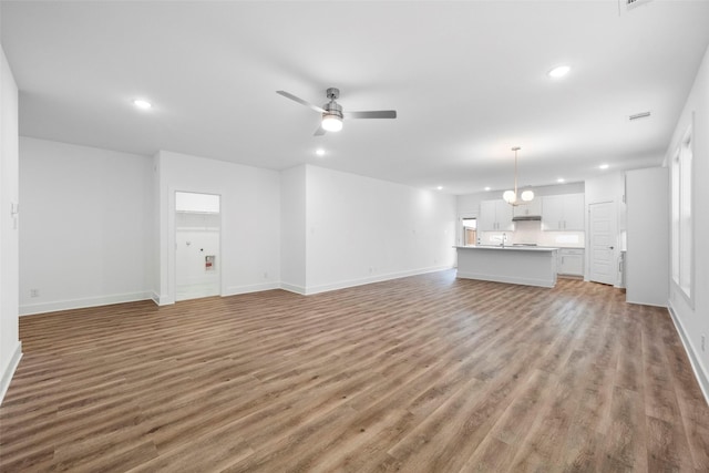 unfurnished living room featuring ceiling fan and wood-type flooring