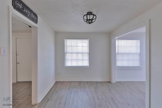 empty room featuring light hardwood / wood-style floors and a textured ceiling