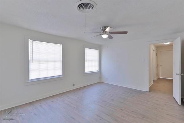 unfurnished room with ceiling fan, light hardwood / wood-style flooring, and a textured ceiling