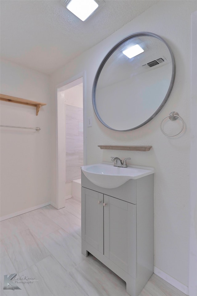 bathroom featuring tile flooring, vanity, and a textured ceiling