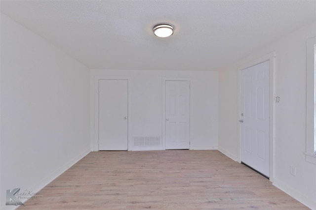 interior space with a textured ceiling and light wood-type flooring