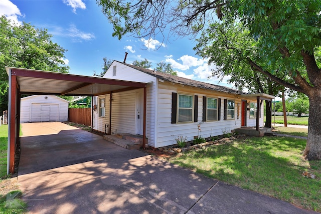 view of front of house with a front lawn, a carport, and an outdoor structure