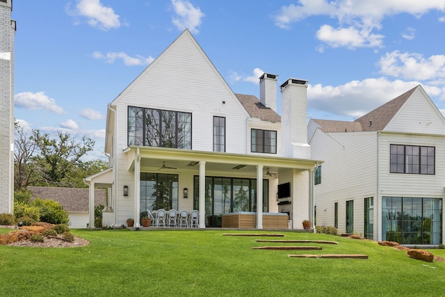 rear view of house featuring a yard and ceiling fan