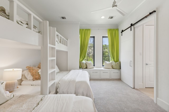 carpeted bedroom featuring a barn door, ceiling fan, and crown molding